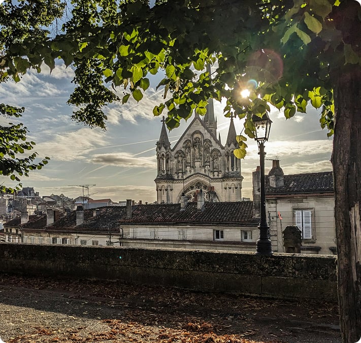 La cathédrale d’Angoulême vue depuis une rue bordée d’arbres