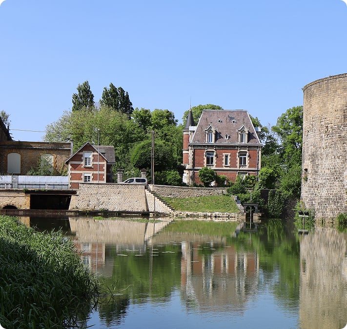 Maisons en pierre au bord de la Meuse, au pied d’une tour médiévale