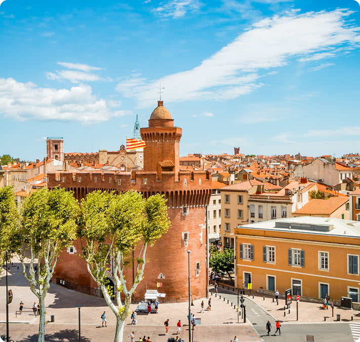 Le Castillet et les toits de Perpignan sous un ciel bleu