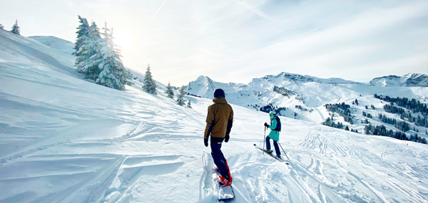 Deux skieurs descendant une piste enneigée