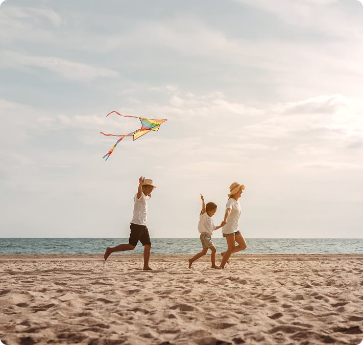 Une famille faisant voler un cerf-volant sur une plage de sable