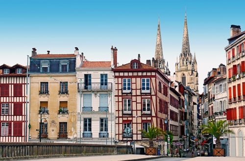 Façades colorées à colombages de Bayonne, avec les flèches de la cathédrale en arrière-plan