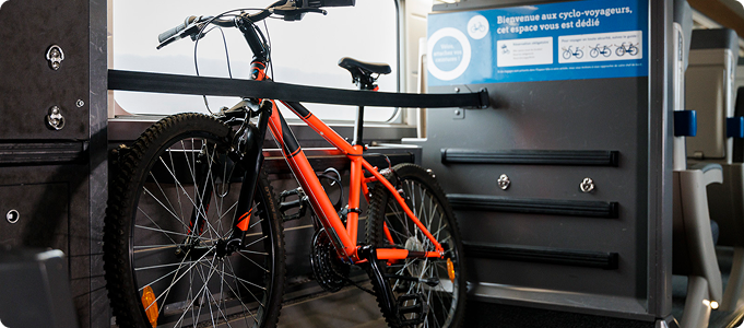 Vélo rangé dans l’espace vélo dédié d’une voiture de TGV&nbsp;INOUI qui est délimité par une sangle