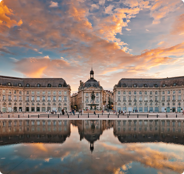 La place de la Bourse à Bordeaux se reflétant dans le miroir d'eau au coucher du soleil